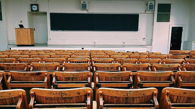 Ein leerer Hörsaal mit Bänken für die Studierenden.