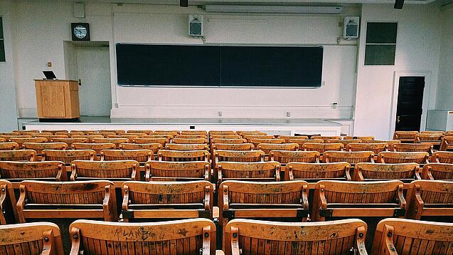 Ein leerer Hörsaal mit Bänken für die Studierenden.