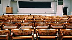 Ein leerer Hörsaal mit Bänken für die Studierenden.