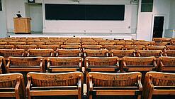 Ein leerer Hörsaal mit Bänken für die Studierenden.