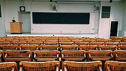Ein leerer Hörsaal mit Bänken für die Studierenden.