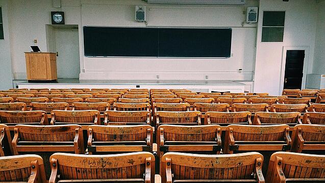 Ein leerer Hörsaal mit Bänken für die Studierenden.