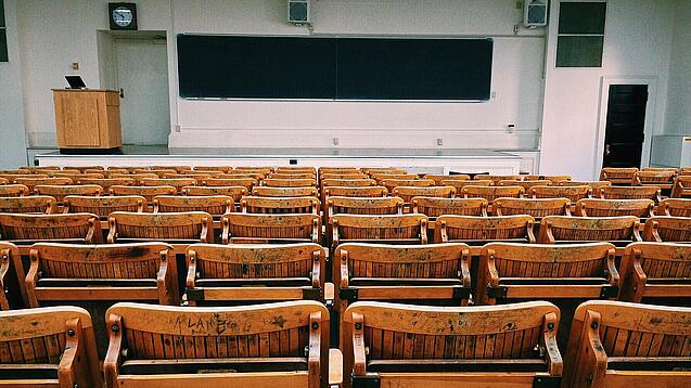 Ein leerer Hörsaal mit Bänken für die Studierenden.