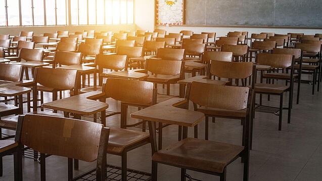 Leerer Klassenraum mit vielen Stühlen und einer Tafel