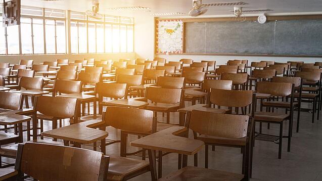 Leerer Klassenraum mit vielen Stühlen und einer Tafel