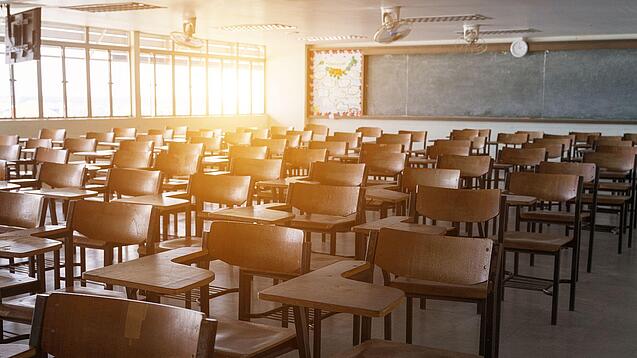 Leerer Klassenraum mit vielen Stühlen und einer Tafel