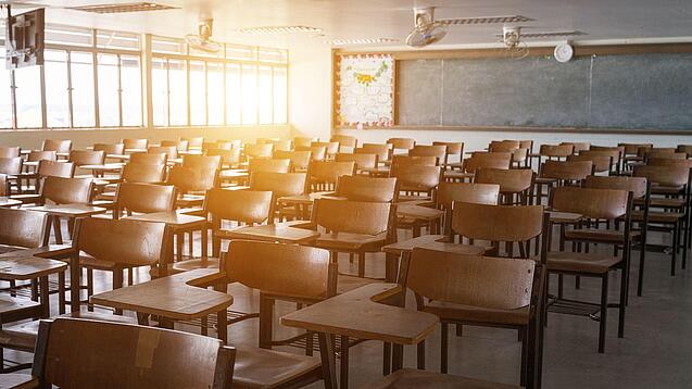 Leerer Klassenraum mit vielen Stühlen und einer Tafel