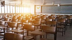 Leerer Klassenraum mit vielen Stühlen und einer Tafel