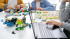 Kinder spielen mit technischen Bauklötzen.