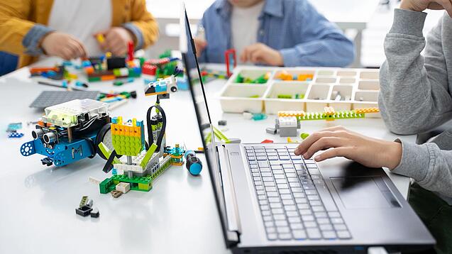 Kinder spielen mit technischen Bauklötzen.