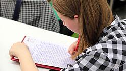 Schülerin schreibt etwas.