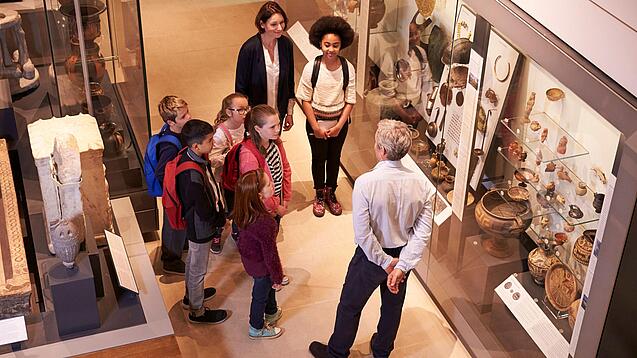 Eine Gruppe Kinder bekommt eine Führung durch ein Museum.