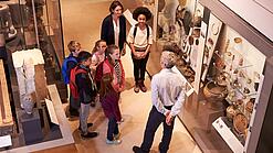 Eine Gruppe Kinder bekommt eine Führung durch ein Museum.