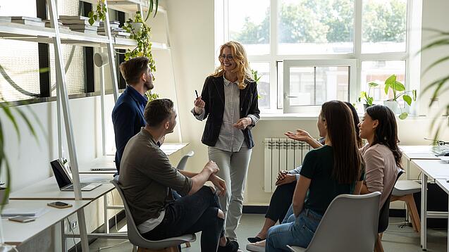 Kleine Gruppe vor unterhält sich in einer Art Büro