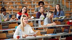 Mehrere Studierende sitzen in einem Hörsaal.