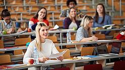 Mehrere Studierende sitzen in einem Hörsaal.