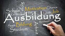 Auf einer Tafel sind verschiedene Wörter um das Wort "Ausbildung" gekritzelt, z. B. Arbeit, Studium, Motivation usw.
