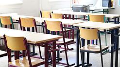 Stühle und Tische in einem Klassenraum.