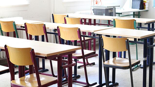 Stühle und Tische in einem Klassenraum.
