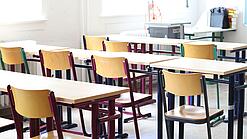 Stühle und Tische in einem Klassenraum.