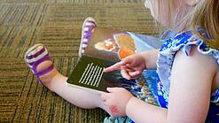 Kleinkinder schaut sich ein Bilderbuch an.