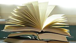 Stapel mit aufgeklappten Büchern