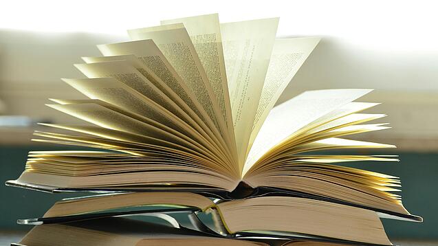 Stapel mit aufgeklappten Büchern
