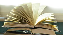 Stapel mit aufgeklappten Büchern