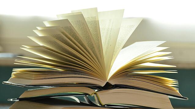 Stapel mit aufgeklappten Büchern