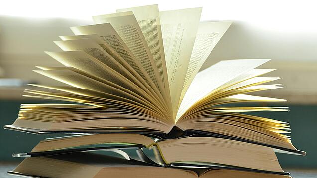 Stapel mit aufgeklappten Büchern