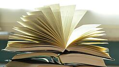 Stapel mit aufgeklappten Büchern