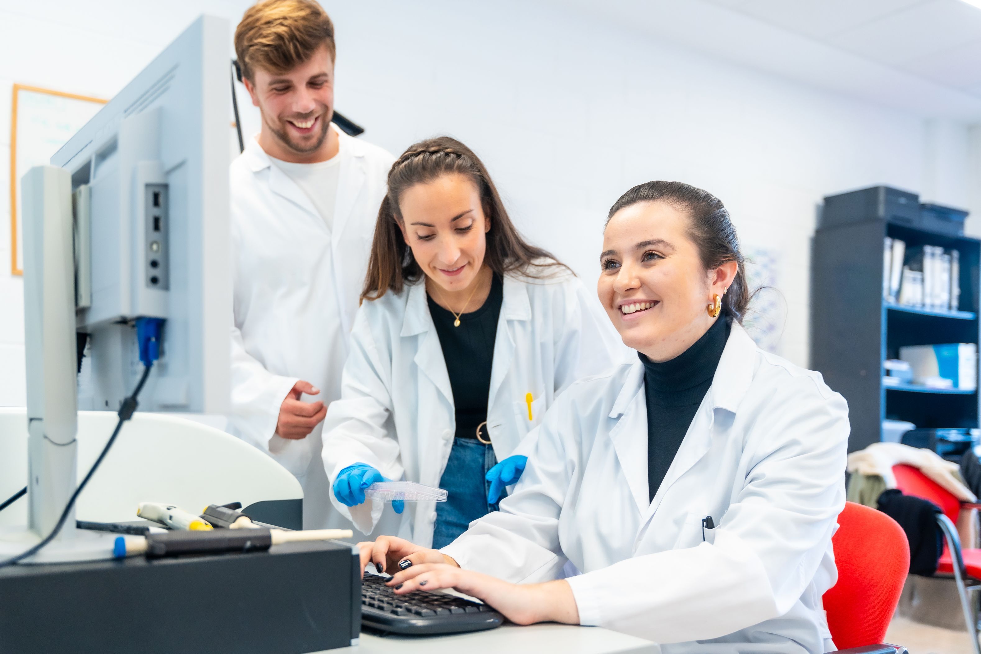 Drei Wissenschaftlerinnen sitzen vor einem Computer und lächeln.